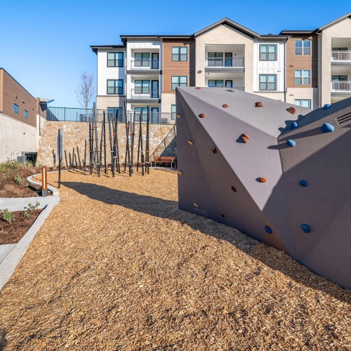climbing wall and poles next to bench